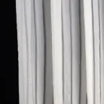 Белая тюль в полоску на окне, создающая уют и светлый акцент