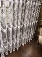 Белая тюль с цветочной вышивкой на вертикальных складках